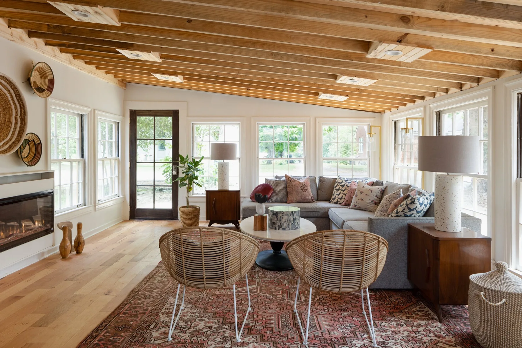 Sunroom with exposed wood beams designed by Holly Thompson Design